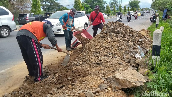 Petugas membersihkan tanah uruk yang dibuang begitu saja di Jalan Jogja-Solo, Klaten. Foto diambil Rabu (12/4/2023).