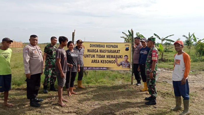 Polisi memasang papan peringatan dilarang mendekati Area Oro-oro Kesongo Blora, Kamis (13/4/2023).