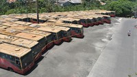 Bus Transjakarta yang terbengkalai itu dalam kondisi kusam, atap berkarat, kaca pecah dan memprihatinkan.  