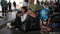 Sejumlah pemudik menunggu bus yang akan ditumpangi dengan duduk di lantai Terminal Pulogebang.