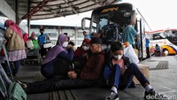 Sebagian pemudik menunggu jadwal keberangkatan dengan duduk bersandar barang bawaan.