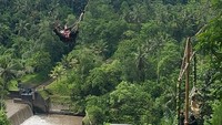 Dia berayun di atraksi terkenal di Ubud yaitu Bali Swing