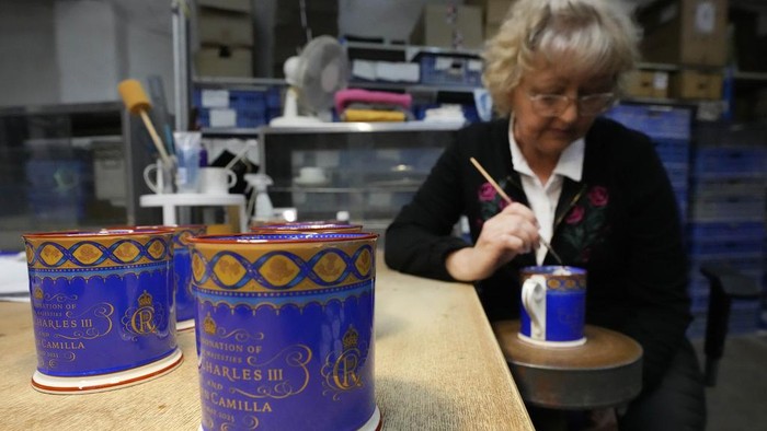 A worker paints the finish on official chinaware in a pottery in Stoke on Trent, Thursday, April 13, 2023. A range of official chinaware produced in Stoke-on-Trent by Royal Collection Trust, a department of the Royal Household, will go on sale on Friday, April 14 to commemorate the upcoming Coronation on May 6, 2023. (AP Photo/Frank Augstein, pool)