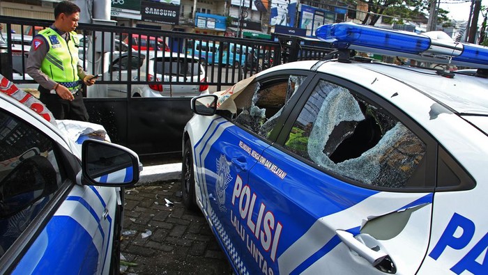 Polisi melihat kondisi mobil patroli yang dirusak oleh orang tidak dikenal (OTK) di Makassar, Sulawesi Selatan, Jumat (14/4/2023). Sejumlah fasilitas milik polisi seperti pos Polantas, kendaraan dinas dan mobil patroli mengalami kerusakan akibat penyerangan OTK yang terjadi di sejumlah lokasi di daerah itu pada Jumat (14/4) dini hari. ANTARA FOTO/Arnas Padda/nym.