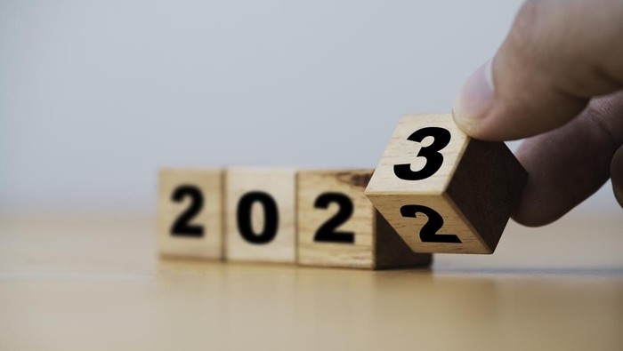 Wooden block cube flipping between 2022 to 2023 for change and preparation merry Christmas and happy new year.