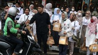 VP CSR Center Department Head Bank Mandiri Diwangkoro A. Ratam (tengah) bersama Ibu-Ibu pelaku usaha binaan Rumah BUMN (RB) Bank Mandiri Bogor saat membagikan paket takjil Ramadan ke masyarakat sekitar, termasuk yayasan panti asuhan, pelintas jalan raya, pengamen, pedagang kaki lima, dan petugas parkir di kawasan Pajajaran, Kota Bogor, Jumat (14/4).