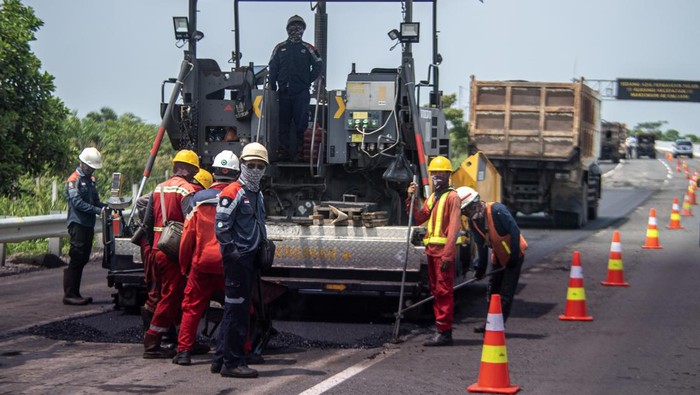 Pekerja dibantu alat berat menyelesaikan pengaspalan Jalan Tol Trans Sumatera ruas Kayu Agung-Palembang (Kapal) di  Kabupaten Ogan Komering Ilir (OKI), Sumatera Selatan, Kamis (13/4/2023). H-9 jelang Hari Raya Idul Fitri 1444 H, sejumlah tiitk di Jalan Tol Trans Sumatera ruas Kayu Agung-Palembang (Kapal) masih dilakukan perbaikan. ANTARA FOTO/Nova Wahyudi/hp.