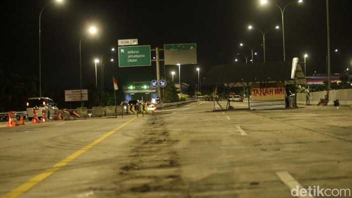 Warga kembali menutup akses Tol Jatikarya, Kamis (13/4/2023) malam.