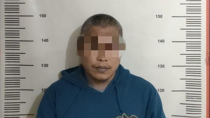 Pelaku penganiayaan anak tiri berinisial RH saat diamankan di Polsek Sekupang.(dok istimewa)