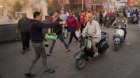 Seorang warga membagikan takjil gratis kepada pengendara sepeda motor di distrik El-Gamaliyya, Kairo, Mesir, Jumat (14/4/2023).