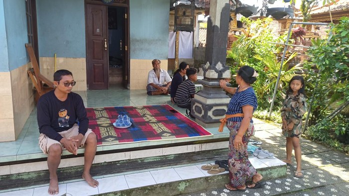 Sang Putu Juliarsana (kiri) bersama keluarganya saat dijumpai di rumah mertuanya, Banjar Lebah, Desa/Kecamatan Marga, Tabanan, Bali, Sabtu (15/4/2023). (chairul amri simabur/detikBali)