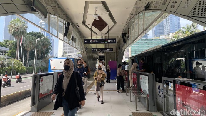 Suasana penumpang hendak menaiki bus transjakarta di Halte Bundaran HI, Sabtu (15/4/2023).