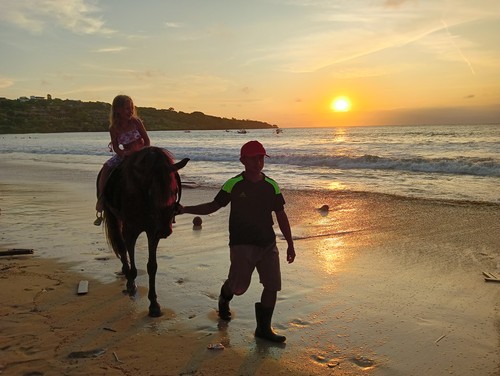 Wisatawan menjajal wisata kuda sembari menyusuri Pantai Jimbaran, Sabtu (15/4/2023).