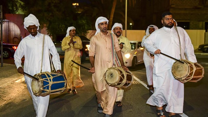 Qatari men play drum and Singing traditional songs to awaken people for sahur meal on a street during Ramadan, in Doha,Qatar on 16 April 2023 . Sahur meal is the last meal before a long day of fasting that starts with the call to prayer at sunrise on Ramadan month. (Photo by Noushad Thekkayil/NurPhoto via Getty Images)