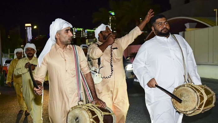 Qatari men play drum and Singing traditional songs to awaken people for sahur meal on a street during Ramadan, in Doha,Qatar on 16 April 2023 . Sahur meal is the last meal before a long day of fasting that starts with the call to prayer at sunrise on Ramadan month.  (Photo by Noushad Thekkayil/NurPhoto via Getty Images)