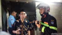 Tidak hanya pedagang, para pengunjung yang masih ada di lokasi juga tampak kalang kabut. Sejumlah petugas Damkar mengarahkan agar mereka tetap tenang saat keluar dari pintu yang aman. (Foto: Deny Prastyo Utomo/detikJatim)