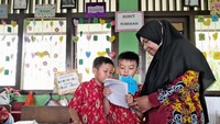 Setelah menulis, siswa juga diajak membaca hasil tulisannya sendiri. Tulisan-tulisan latihan beserta gambarnya dikerjakan serius oleh siswa. Salah satu tulisan di media pembelajaran ini dinamai Kalimu, alias Kalimat Murid. Foto: Trisna Wulandari/detikEdu