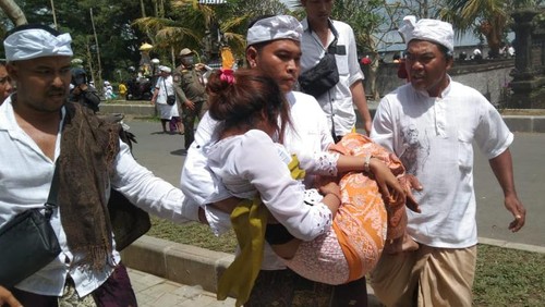 Pemedek yang pingsan akibat berdesakan saat melakukan persembahyangan di Pura Agung Besakih, Minggu (16/4/2023). (Foto: istimewa)