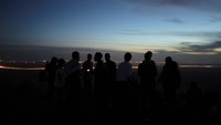Warga berbuka puasa sambil menikmati matahari tenggelam.