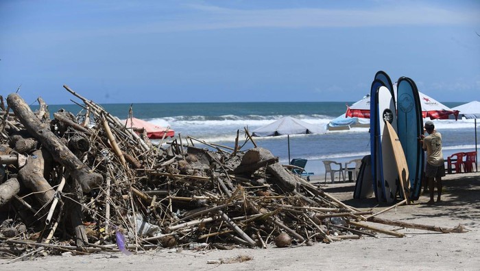 A tourist prepares to go surfing on Kuta Beach in Denpasar, on Indonesia resort island of Bali, on April 16, 2023. (Photo by SONNY TUMBELAKA / AFP) (Photo by SONNY TUMBELAKA/AFP via Getty Images)