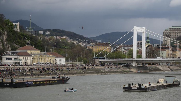 63-year-old circus artist Laszlo Simet walks on a tightrope across the two banks of the river Danube in downtown Budapest on Saturday, April 15, 2023. Simet's was the first man to cross the almost 300 meters wide Danube without a safety rope at a height of 30 metres on a 22-millimetre rope in-between the Buda and Pest sides of the Hungarian capital. (AP Photo/Denes Erdos)