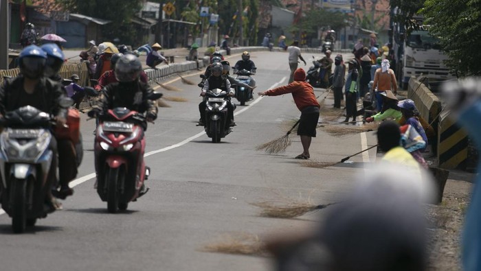 Aksi Pencari Sedekah dengan Sapu di Jembatan Sewo Sejumlah warga menunggu pengendara memberi sedekah dengan melempar uang di Jembatan Sewo, Jalur Pantura Sukra Indramayu, Jawa Barat, Senin (17/4/2023). Aksi mengambil uang sedekah menggunakan sapu tersebut dapat membahayakan keselamatan pengguna jalan terutama saat arus mudik. ANTARA FOTO/Dedhez Anggara/aww.