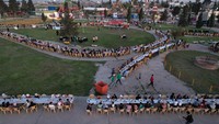 Uniknya, acara buka puasa bersama ini digelar di sebuah taman, jalan setapak di taman itu dipenuhi meja yang mengular.  