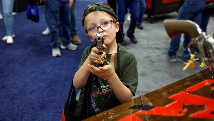 Children try out guns during the National Rifle Association (NRA) annual convention in Indianapolis, Indiana, U.S., April 15, 2023. REUTERS/Evelyn Hockstein REFILE - CORRECTING INFORMATION
