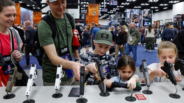 Children try out guns during the National Rifle Association (NRA) annual convention in Indianapolis, Indiana, U.S., April 15, 2023. REUTERS/Evelyn Hockstein REFILE - CORRECTING INFORMATION