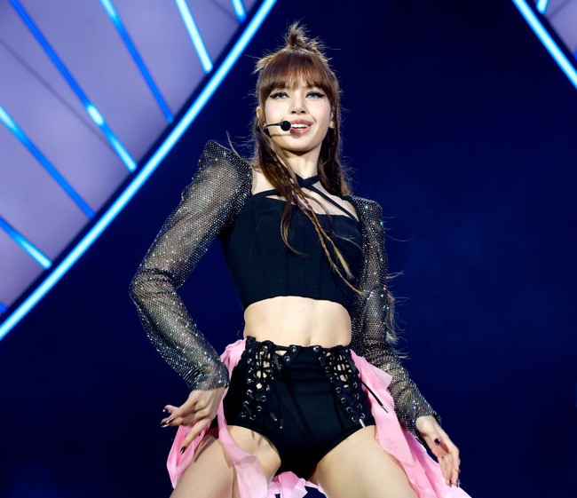 Lisa menonjolkan gaya edgy-nya dalam balutan blouse lengan panjang ketat dengan shoulder pads yang mengaksentuasi bahu. Idol K-Pop asal Thailand ini juga mengenakan micro shorts berhias payet dan detail ekor berbahan lace di bagian belakang. Foto: Getty Images for Coachella/Frazer Harrison