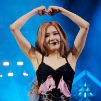 Rose mengenakan romper hitam dengan aksen ikat pinggang serta lace. Detail ruffle pink yang kontras dengan romper membuat penampilannya lebih atraktif. Foto: Getty Images for Coachella/Frazer Harrison