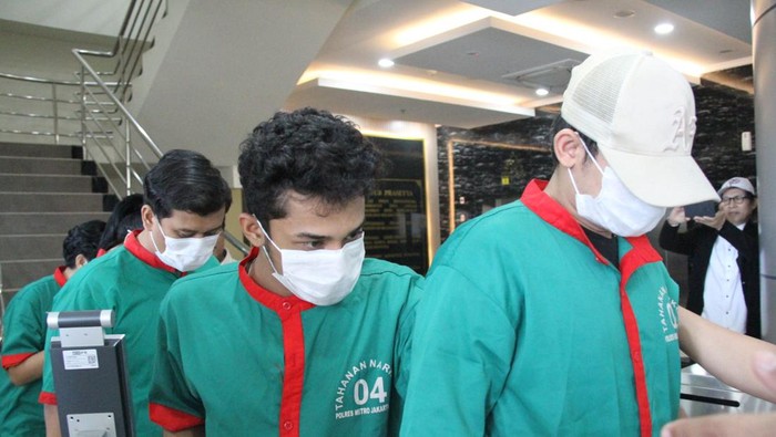 Hud Filbert bertopi dan berbaju tahanan warna hijau saat dirilis polisi