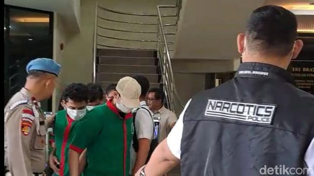 Hud Filbert bertopi dan berbaju tahanan warna hijau saat dirilis polisi