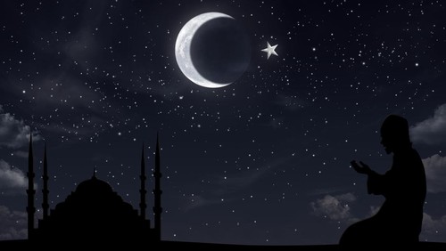 Praying muslim and mosque at night sky hilal half moon