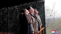 Foto-foto yang dirilis media pemerintah Korut menunjukkan Kim Jong Un, yang didampingi anak perempuannya, menyaksikan rudal berwarna hitam-putih melesat ke udara di tengah kepulan asap, dan tersenyum gembira setelah peluncuran itu disebut berlangsung sukses.  