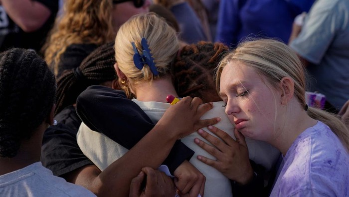 Pesta Ultah Remaja di Alabama Jadi Pembantaian, 4 Orang Tewas Community members embrace each other during a vigil the day after a shooting during a teenager's birthday party at Mahogany Masterpiece Dance Studio in Dadeville, Alabama, U.S. April 16, 2023. REUTERS/Cheney Orr