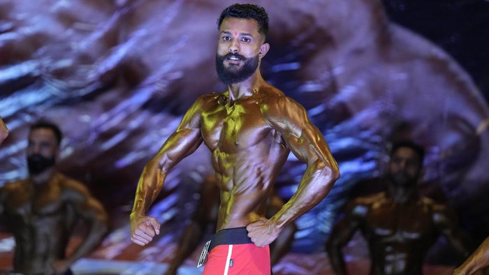 Contestants flex their muscles during a state level body building championship in Jammu, India, Sunday, April 16, 2023. (AP Photo/Channi Anand)