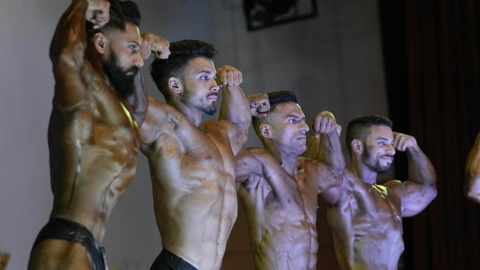 Contestants flex their muscles during a state level body building championship in Jammu, India, Sunday, April 16, 2023. (AP Photo/Channi Anand)