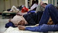 Pemudik beristirahat dengan tiduran di dalam kapal.