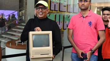 Seorang pengunjung membawa komputer Apple jadul sebagai perayaan dibukanya Apple Store pertama India. Sebenarnya, pasar India didominasi oleh ponsel kelas menengah ke bawah dengan Xiaomi sebagai produsen terlaris. Pangsa pasar Apple terhitung kecil di sana. Foto: Getty Images