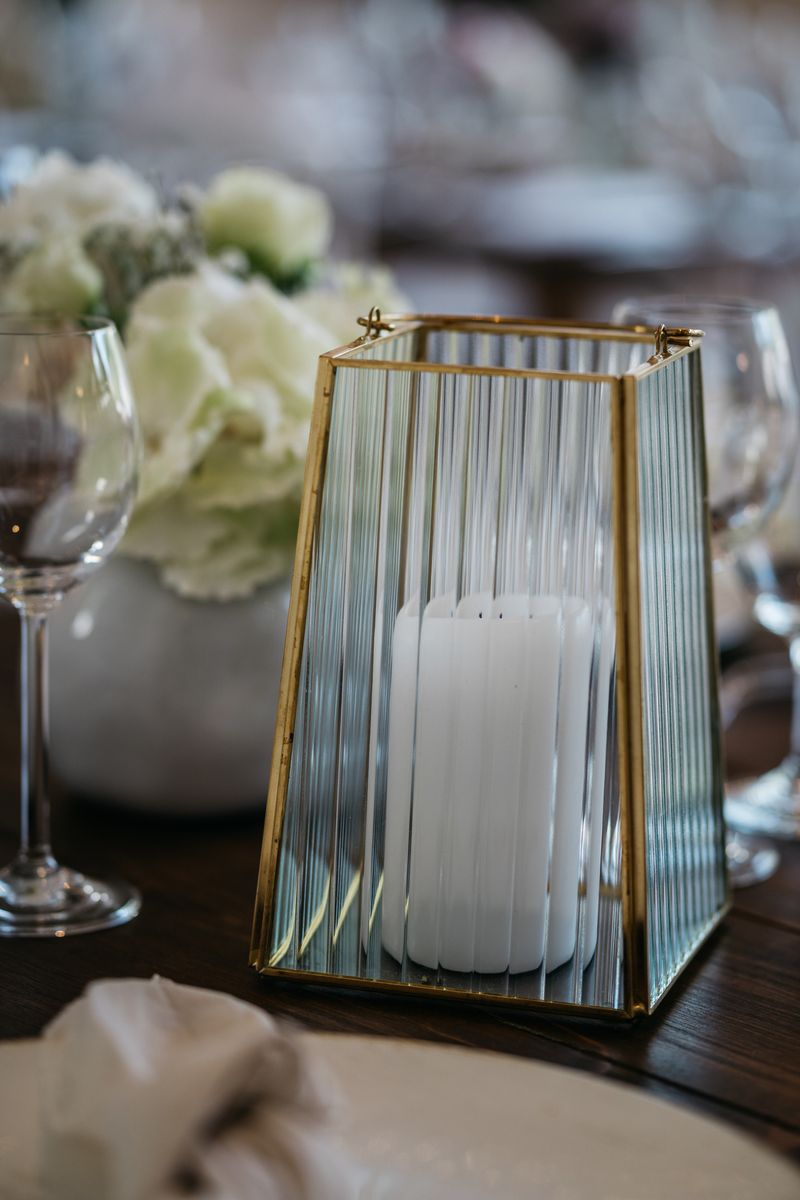 White candle in a golden framed glass as centrepiece of a table decor