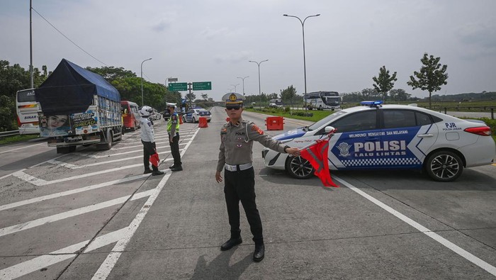 Polisi mengalihkan kendaraan bermotor dari arah Cirebon ke Jakarta untuk keluar melalui Gerbang Tol Subang saat sterilisasi ruas Tol Cipali dalam rangka penerapan kebijakan satu arah di Subang, Jawa Barat, Selasa (18/4/2023). Korlantas Polri merekayasa lalu lintas satu arah di ruas Tol Cipali hingga Kalikangkung pada Selasa (18/4) pukul 14.00-24.00 WIB dan Rabu (19/4)-Jumat (21/4) pukul 08.00-24.00 WIB untuk mengurangi potensi kemacetan kendaraan bermotor saat arus mudik Lebaran. ANTARA FOTO/Aditya Pradana Putra/tom..