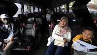 Seorang warga tampak senang saat mengikuti mudik gratis bersama Kimia Farma.