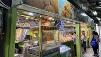 Cakue Peneleh ini berlokasi di gedung lama Pasar Atom, berada di sebuah lorong yang sekelilingnya juga menjual camilan. Gerai Cakue Peneleh terlihat paling terang dan ramai pelanggan. Foto: detikFood/Yenny Mustika Sari