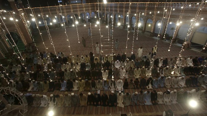People arrive for prayer in the historical Sunahri mosque which is decorated with lights on the eve of 'Shab-e-Qadr' or Night of Power marking the 27th day of Islamic fasting month of Ramadan in Peshawar, Pakistan, Monday, April 17, 2023. (AP Photo/Muhammad Sajjad)