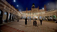 Orang-orang tiba untuk sholat di masjid bersejarah Sunahri yang dihiasi dengan lampu pada malam Shab-e-Qadr atau Malam Kekuasaan menandai hari ke-27 bulan puasa Ramadhan di Peshawar, Pakistan, Senin (17/4/2023). Masjid terletak di dekat Nothia, area pasar yang sibuk di kanton.