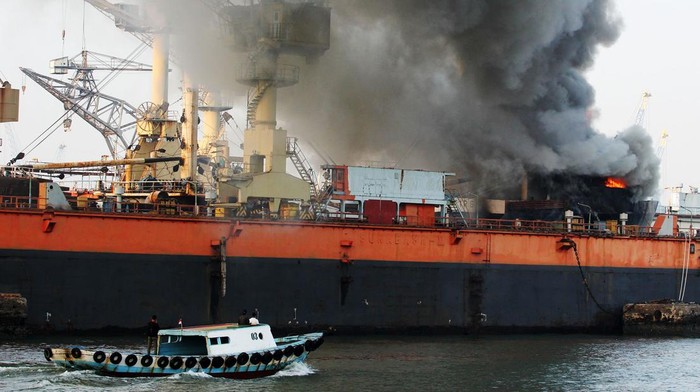 Petugas dengan menggunakan kapal tunda (tug boat) menyemprotkan air ke KM Anugerah Mandiri 8 yang terbakar di atas dok apung PT DOK dan Perkapalan Surabaya, Pelabuhan Tanjung Perak, Surabaya, Jawa Timur, Rabu (19/4/2023). Sejumlah unit kendaraan pemadam kebakaran dan kapal tunda (tug boat) dikerahkan untuk memadamkan kebakaran kapal kargo yang sedang dalam perbaikan tersebut. ANTARA FOTO/Didik Suhartono/YU