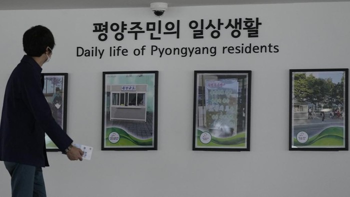 A visitor walks in front of pictures showing the North Korea's capitol Pyongyang at the unification observatory in Paju, South Korea, Wednesday, April 19, 2023. North Korean leader Kim Jong Un said his country has completed the development of its first military spy satellite and ordered officials to go ahead with its launch as planned, state media reported Wednesday. (AP Photo/Lee Jin-man)