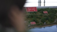 Gambar yang diterbitkan KCNA menunjukkan Kim berkeliling badan antariksa dengan putrinya. Barang-barang yang dia periksa, serta bagan dan pajangan dinding lainnya di beberapa gambar dikaburkan. AP/Lee Jin-man  