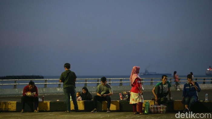 Menikmati Senja di Pelabuhan Merak Sejumlah pemudik tampak menunggu memasuki kapal di pelabuhan Merak, Banten, Rabu (19/4/2023). Terlihat para pemudik berfoto atau hanya sekedar duduk di dermaga untuk menikmati matahari terbenam sambil menunggu kapal.